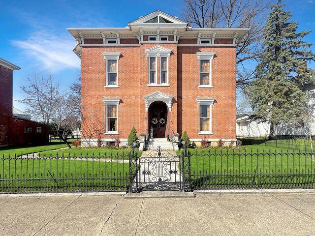 59 S Chillicothe St, South Charleston, OH 45368 - italianate-style house with brick siding, a front lawn, and a fenced front yard
