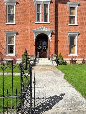59 S Chillicothe St, South Charleston, OH 45368 - view of exterior entry featuring a lawn and brick siding