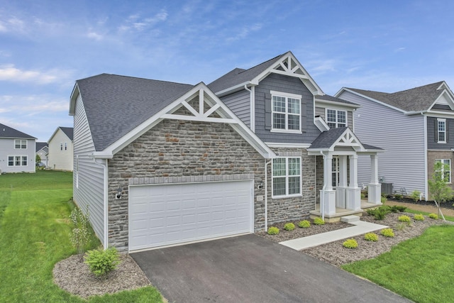 121 E Wind Rd, Delaware, OH 43015 - view of front of house with stone siding, aphalt driveway, and a front yard