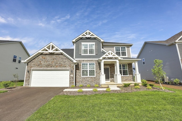 121 E Wind Rd, Delaware, OH 43015 - craftsman-style home featuring stone siding, a front lawn, driveway, and an attached garage