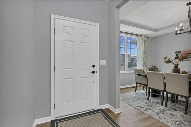 121 E Wind Rd, Delaware, OH 43015 - foyer with baseboards, a chandelier, and wood finished floors