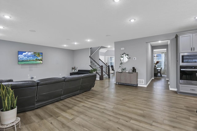 121 E Wind Rd, Delaware, OH 43015 - living room featuring stairs, light wood-style flooring, visible vents, and recessed lighting