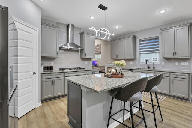 121 E Wind Rd, Delaware, OH 43015 - kitchen with light wood-style flooring, a sink, wall chimney exhaust hood, stainless steel appliances, and gray cabinets