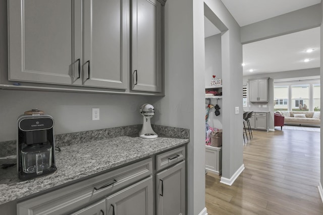 121 E Wind Rd, Delaware, OH 43015 - kitchen with light wood finished floors, open floor plan, light stone counters, and gray cabinets