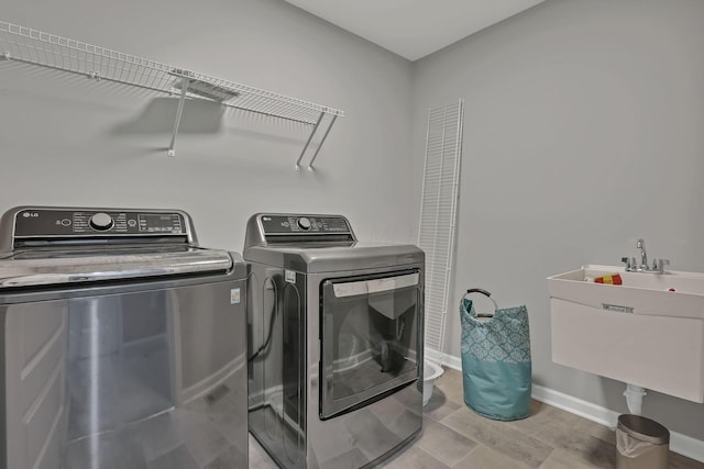 121 E Wind Rd, Delaware, OH 43015 - washroom featuring washer and clothes dryer, laundry area, a sink, and baseboards
