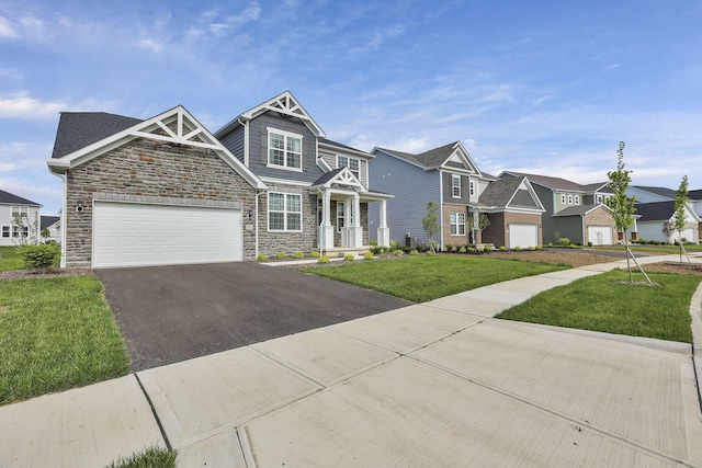 121 E Wind Rd, Delaware, OH 43015 - craftsman house featuring driveway, a front yard, a garage, a residential view, and stone siding