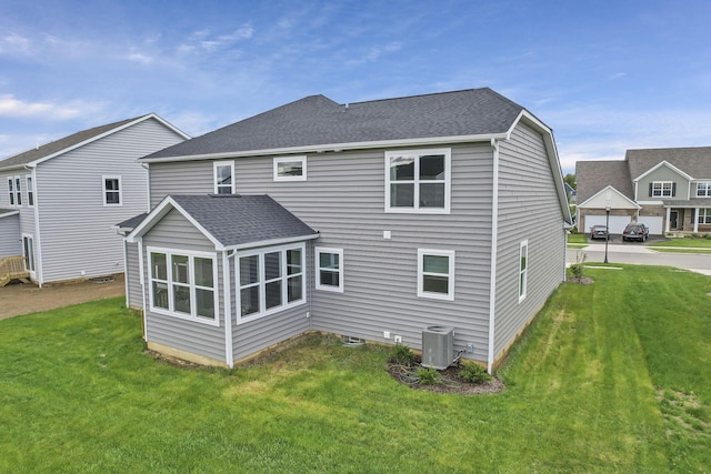 121 E Wind Rd, Delaware, OH 43015 - rear view of house with roof with shingles, a lawn, and central AC