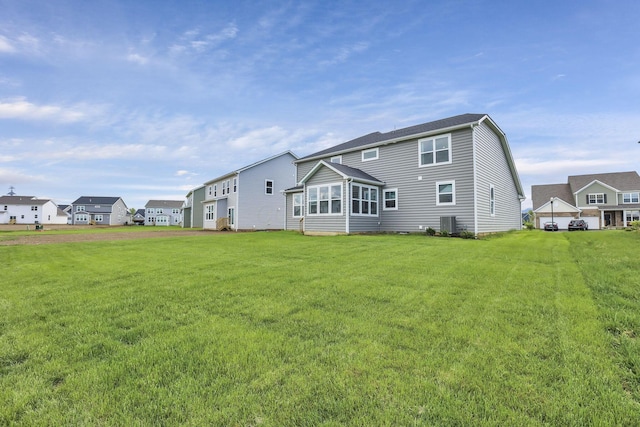 121 E Wind Rd, Delaware, OH 43015 - rear view of house featuring central AC unit and a lawn