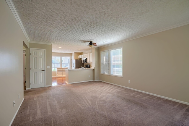 unfurnished living room featuring ornamental molding, light colored carpet, a ceiling fan, and baseboards