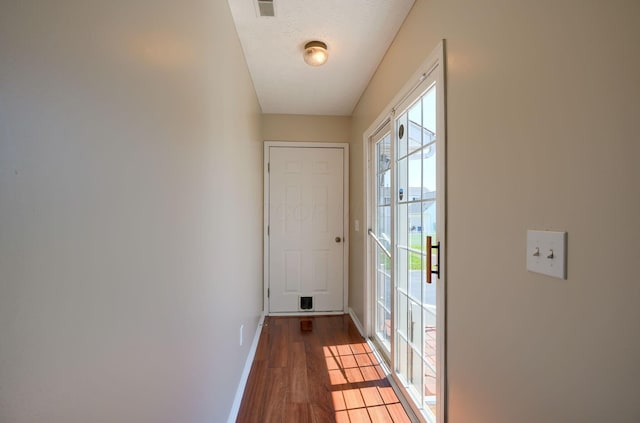 doorway featuring wood finished floors and baseboards