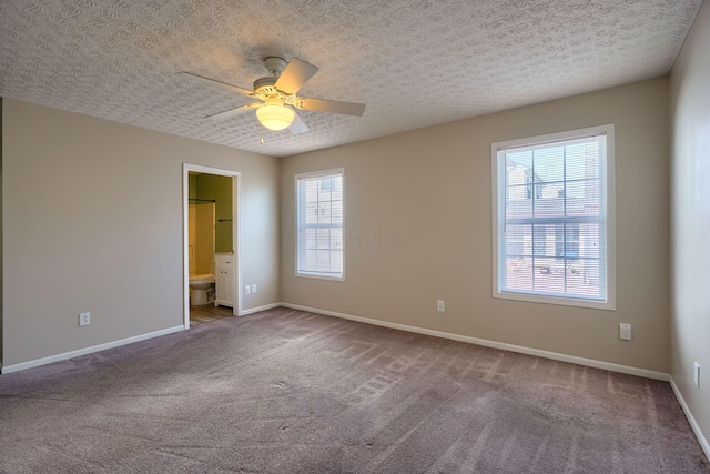 unfurnished bedroom with carpet floors, baseboards, and connected bathroom