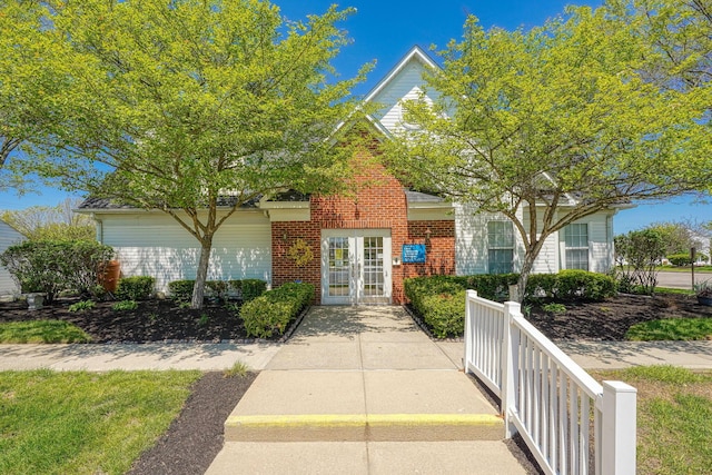view of exterior entry featuring french doors and brick siding