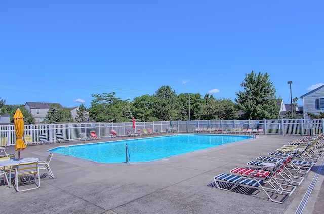 community pool featuring fence and a patio