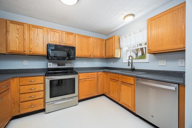 1418 Brookforest Dr, Columbus, OH 43204 - kitchen with light floors, stainless steel appliances, dark countertops, and a sink