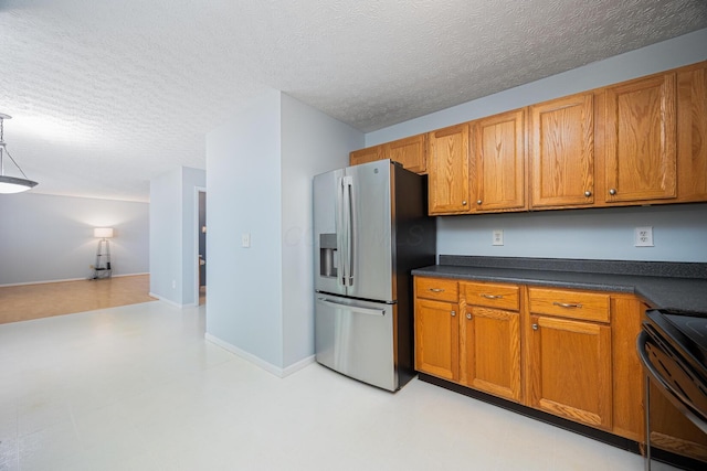 1418 Brookforest Dr, Columbus, OH 43204 - kitchen featuring brown cabinets, stainless steel fridge, black range with electric stovetop, dark countertops, and a textured ceiling