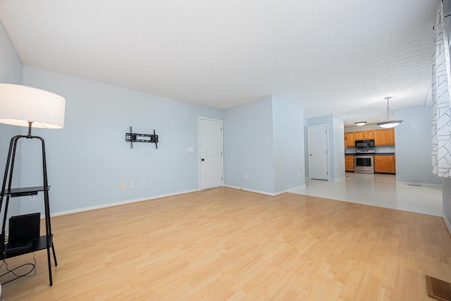 1418 Brookforest Dr, Columbus, OH 43204 - unfurnished living room featuring visible vents, baseboards, and light wood-type flooring