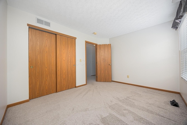 1418 Brookforest Dr, Columbus, OH 43204 - unfurnished bedroom featuring a closet, visible vents, baseboards, a textured ceiling, and light colored carpet