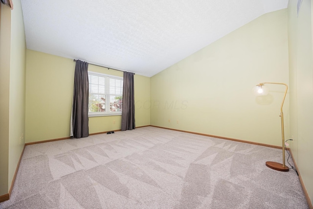 1418 Brookforest Dr, Columbus, OH 43204 - carpeted spare room with a textured ceiling, vaulted ceiling, and baseboards
