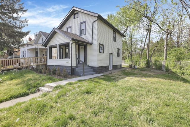 exterior space with fence, a wooden deck, and a yard
