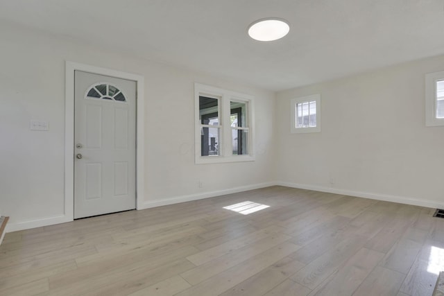 spare room with visible vents, light wood-style flooring, and baseboards