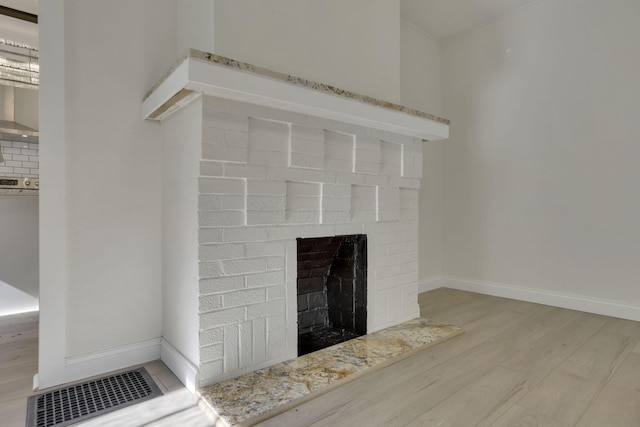 room details with a fireplace, wood finished floors, and baseboards