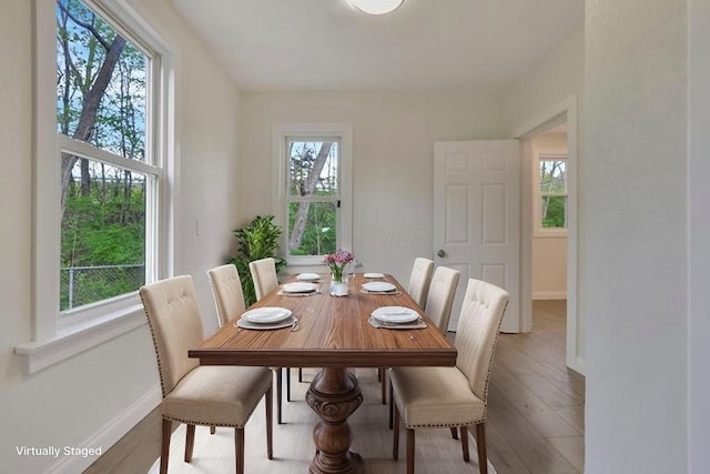 dining space featuring wood finished floors and baseboards