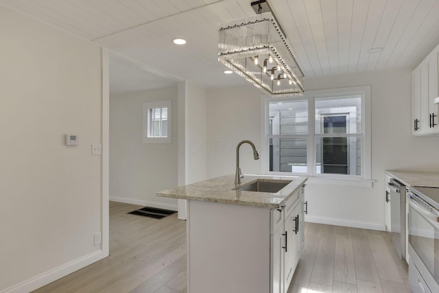 kitchen featuring light wood-type flooring, baseboards, and a sink