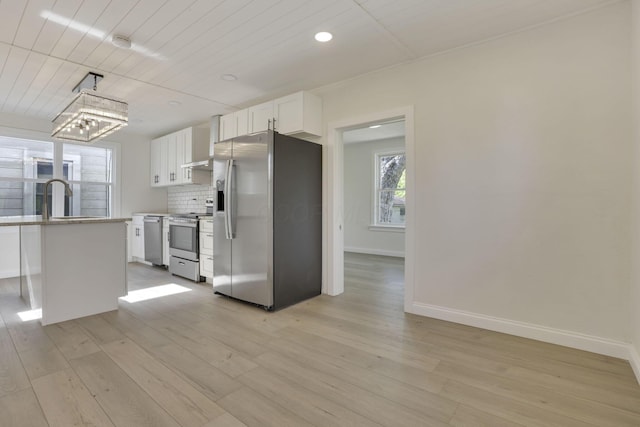 kitchen featuring baseboards, recessed lighting, stainless steel appliances, light wood-style floors, and white cabinetry