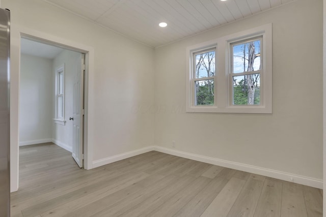 empty room featuring baseboards, light wood-type flooring, and recessed lighting