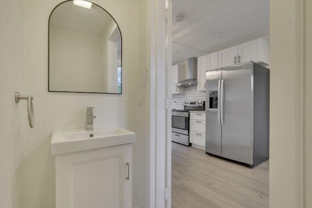 interior space with wood finished floors, tasteful backsplash, and vanity