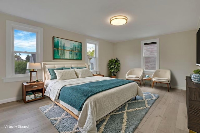 bedroom featuring baseboards and light wood finished floors