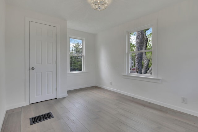 interior space with wood finished floors, visible vents, and baseboards