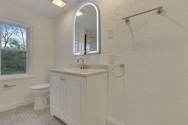bathroom with tile patterned floors, toilet, vanity, and baseboards