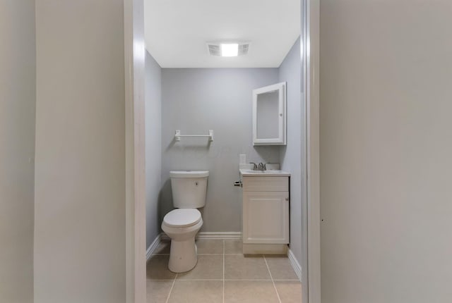 bathroom featuring tile patterned flooring, visible vents, vanity, toilet, and baseboards