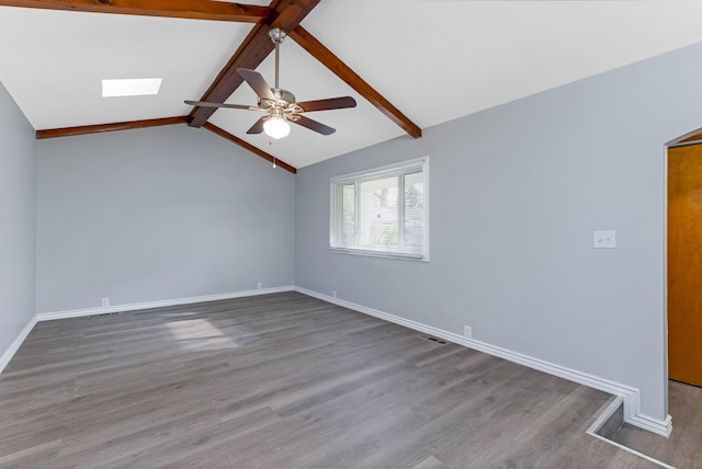 spare room featuring ceiling fan, visible vents, wood finished floors, baseboards, and vaulted ceiling with beams