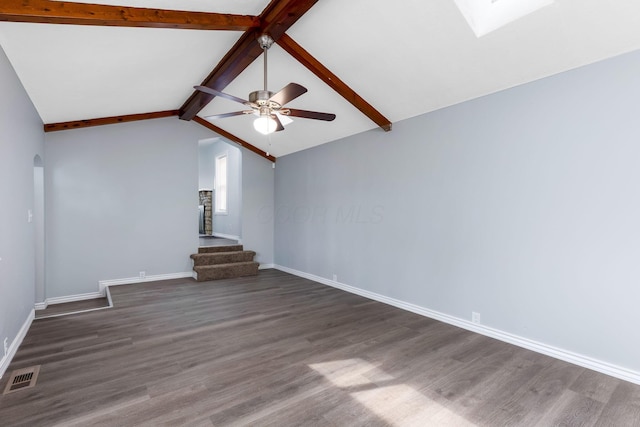 unfurnished living room with baseboards, visible vents, lofted ceiling with skylight, and dark wood-type flooring