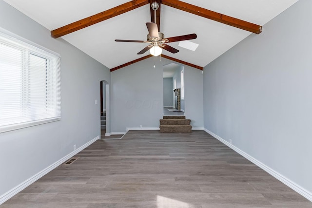 unfurnished living room with a ceiling fan, visible vents, arched walkways, stairway, and lofted ceiling with beams