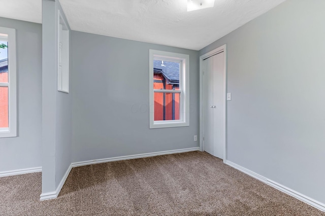spare room featuring baseboards and carpet