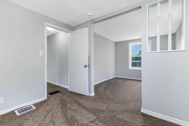 carpeted empty room featuring visible vents and baseboards