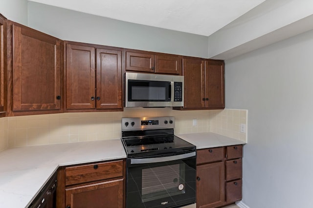 kitchen featuring appliances with stainless steel finishes, light stone countertops, and tasteful backsplash