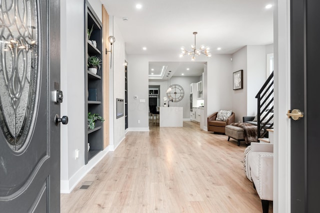 foyer with a notable chandelier, light wood-style flooring, stairs, recessed lighting, and baseboards