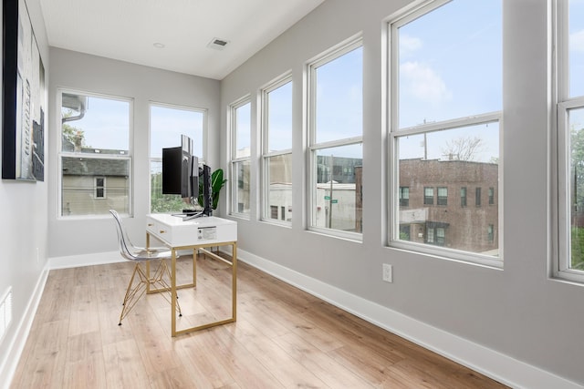 office featuring baseboards, visible vents, plenty of natural light, and light wood-style floors