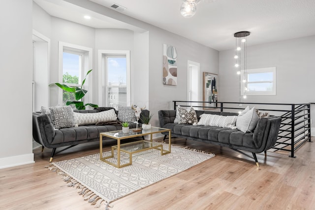 living room with baseboards, wood finished floors, and visible vents