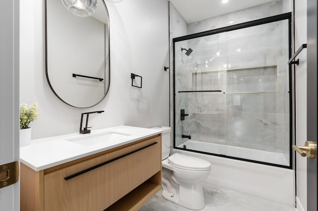 full bath featuring vanity, bath / shower combo with glass door, and toilet