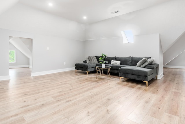 living area featuring visible vents, vaulted ceiling, light wood-type flooring, baseboards, and recessed lighting