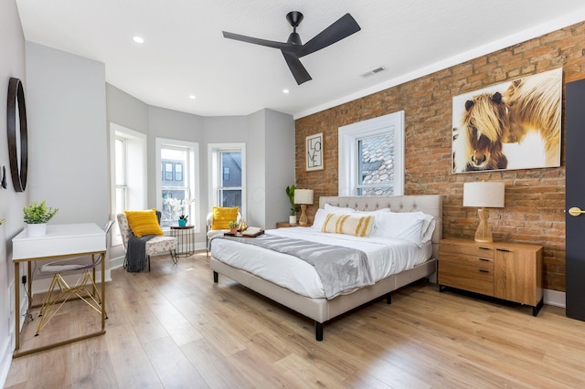 bedroom with brick wall, light wood-style flooring, recessed lighting, baseboards, and visible vents
