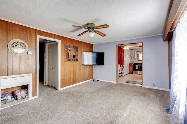 12500 E St, Howard, OH 43028 - unfurnished living room with wooden walls, ornamental molding, baseboards, carpet flooring, and ceiling fan