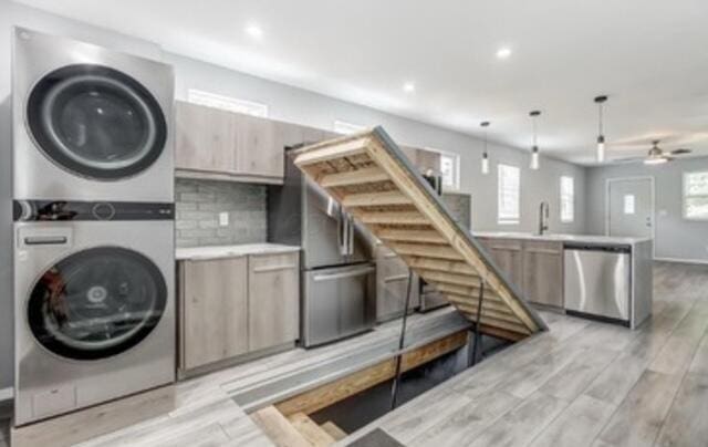 laundry room with stacked washer and dryer, a ceiling fan, recessed lighting, and light wood-style floors