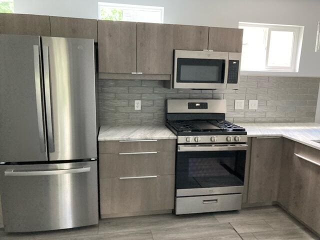 kitchen featuring light countertops, tasteful backsplash, and stainless steel appliances