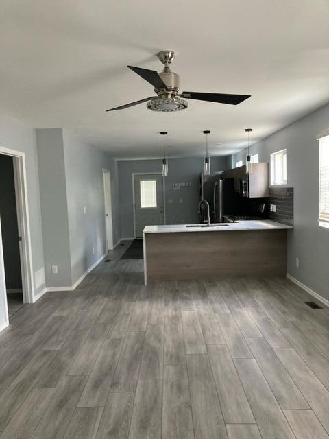 kitchen featuring light countertops, a ceiling fan, wood finished floors, and a wealth of natural light